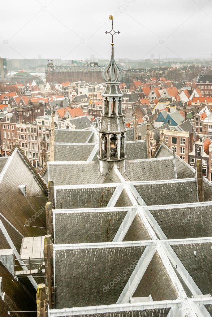 View from the tower of the Oude Kerk (the Old Church) over the church roof and smaller tower, and the inner city with old medieval houses of Amsterdam. In the background the Scheepsvaartmuseum (the National Maritime Museum). Amsterdam, the Netherland