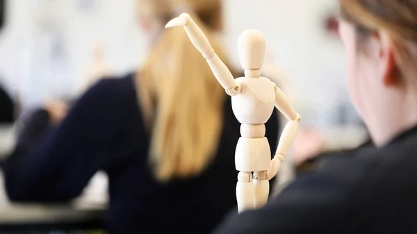 Visual Art high school students working from wooden mannequins practicing drawing human fugure and correct proportion. Artists being creative the art room. Creativity inspiration concept