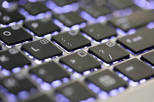 close up of the question mark symbol special character on an illuminated keyboard on a laptop or computer.