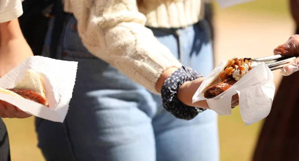 sausage sizzle, steak sandwiches. Outdoor bbq cook out with bread sauce ketchup utensils. Variety of images depicting barbecued meats and feeding many people.