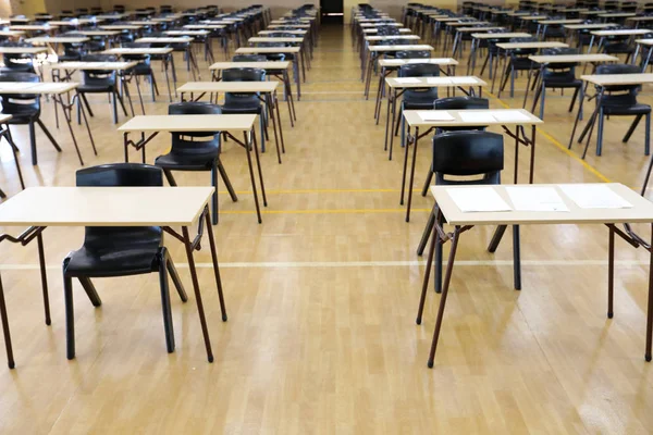interior inside of an exam examination room or hall set up ready for students to sit test. multiple desks tables and chairs. Education, school, student life concept