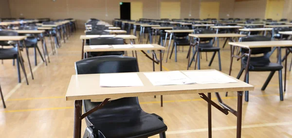 various views of an exam examination room or hall set up ready for students to sit test. multiple desks tables and chairs. Education, school, student life concept