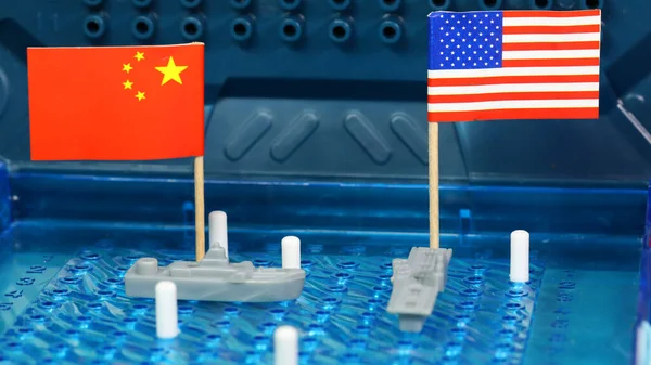 American, U.S, USA United States of American Naval Navy warship meet Chinese navy ship on a Battleship Board game. National flags. Disputed South China sea  navigation territory concept.