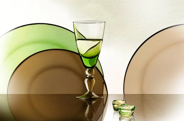 Ein Glas Neben Einem Stapel Weißer Teller Auf Weißem Hintergrund — Stockfoto