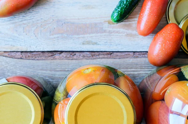 Vista superior de frascos con tomates enlatados y pepinos — Foto de Stock