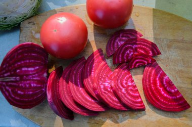 Bright maroon beet slices on a wooden cutting board clipart
