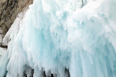 Baykal, buz blokları ve sahil kayalar üzerinde buz sarkıtları, sahilinde dalgaların buz sıçraması.