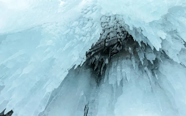 Eisspritzer von Wellen an den Ufern des Baikalsees, Eisblöcke und Eiszapfen an den Küstenfelsen. — Stockfoto