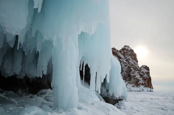 Eisspritzer von Wellen an den Ufern des Baikalsees, Eisblöcke und Eiszapfen an den Küstenfelsen. — Stockfoto