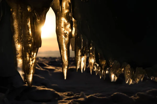 Uitzicht vanaf de ijsgrot via sprankelende Stalactiet op zonsondergang. Het Baikalmeer — Gratis stockfoto