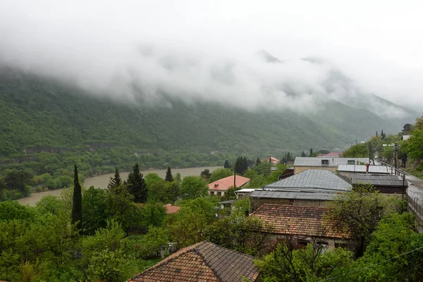 Sisli yağmurlu sabah Mtskheta ve Kura nehri sokaklarına bakış