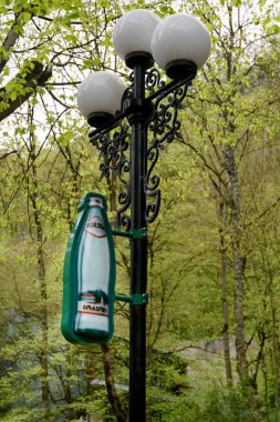 Borjomi, Gürcistan - 04 Mayıs - 2019: Borjomi Sembolü - son sütun üzerinde dekorasyon olarak maden suyu şişesi. Borjomi Parkı'nın merkezi