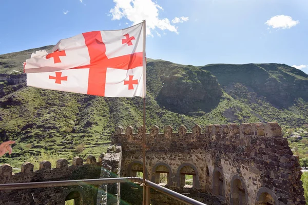 Khertvisi, Georgia-Mei, 05 2019: Tembok benteng Khertvisi dengan celah-celah dan bendera Georgia. Samtskhe-Javakheti wilayah, selatan Georgia — Stok Foto