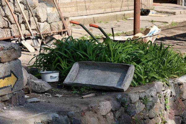 Der alte Trog, der für die Zucht von Beton verwendet wird, liegt im Gras neben dem Haus. Das Dorf Chertvisi — Stockfoto