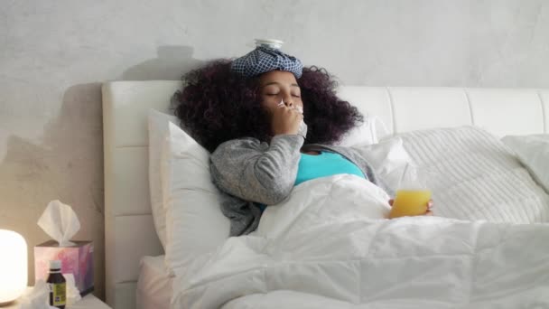 Слабая молодая женщина лежит в постели от гриппа и холода — стоковое видео