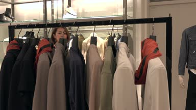 Asya insanlar moda ürünler ve aksesuarlar için alışveriş. Japon kadın lüks mağaza alışveriş merkezi içinde. İstemci ceket ve giyim mağaza satın alma