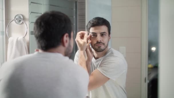 Latino hombre recortando cejas para el cuidado del cuerpo en casa — Vídeo de stock