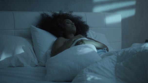 Бессонница для молодой черной женщины, спящей в постели дома — стоковое видео