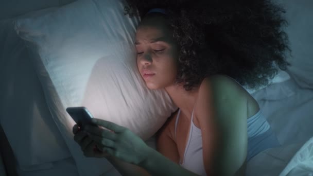 Joven mujer negra mensajes de texto con Smartphone en la cama — Vídeos de Stock