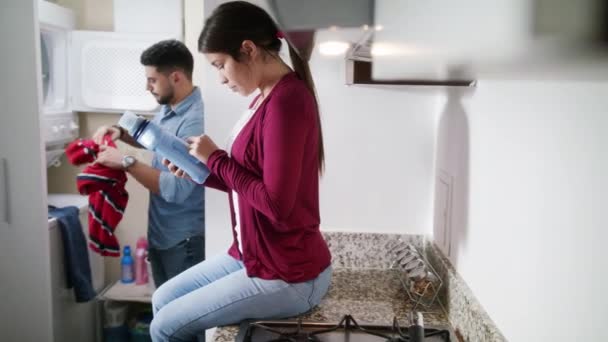 Man en vrouw doen klusjes kleren wassen — Stockvideo