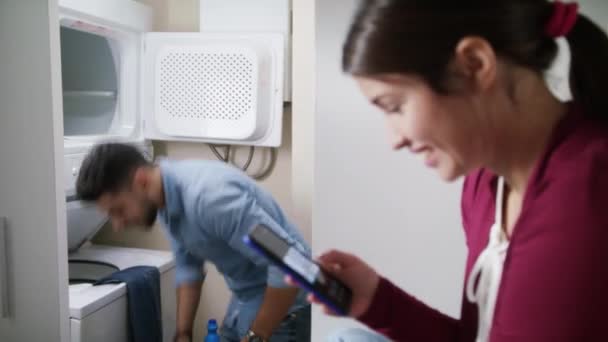 Чоловік і жінка займаються пранням одягу — стокове відео
