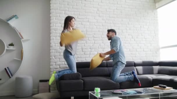 Retrato de pareja joven jugando a la pelea de almohadas — Vídeo de stock