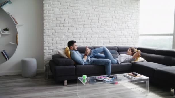 Людина масажуючи подруга ноги на дивані в домашніх умовах — стокове відео
