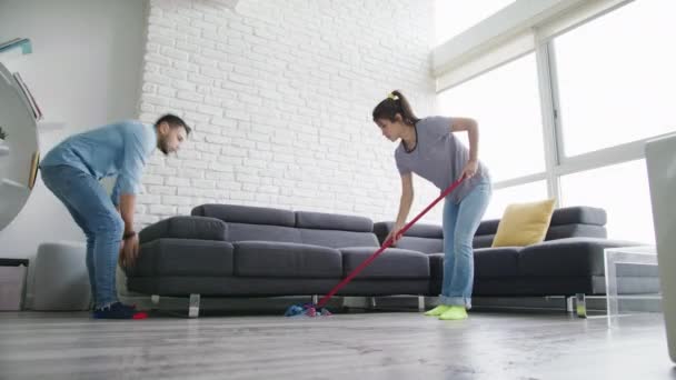 Чоловік і жінка роблять проблеми прибирання підлоги — стокове відео
