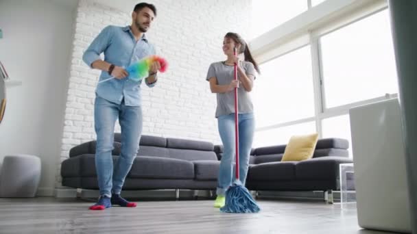 Мужчина и женщина танцуют во время уборки дома — стоковое видео