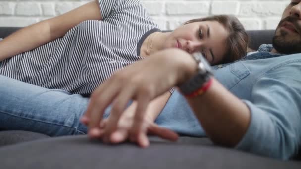 Retrato de una joven sosteniendo las manos de su novio en un sofá — Vídeo de stock