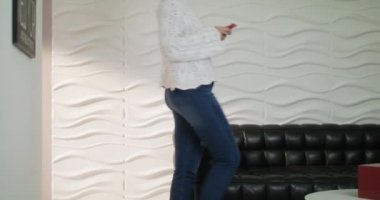 Genç Latin kız kanepe cep telefonu ile mesajlaşma