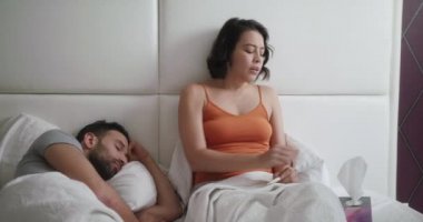 Genç kadın adamla yatakta soğuk için hapşırma