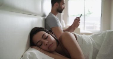 Genç çift yatakta adam manifatura Smartphone cep telefonu ile hile ile