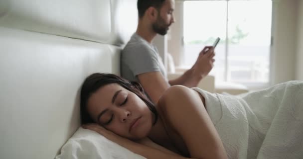 Jeune couple au lit avec tromperie homme textos sur Smartphone — Video