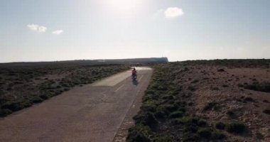 Erkek ve kadın Lampedusa Adası Akdeniz'de arka plan ile yaz tatilinde İtalya Caddesi üzerinde motosiklet Binme