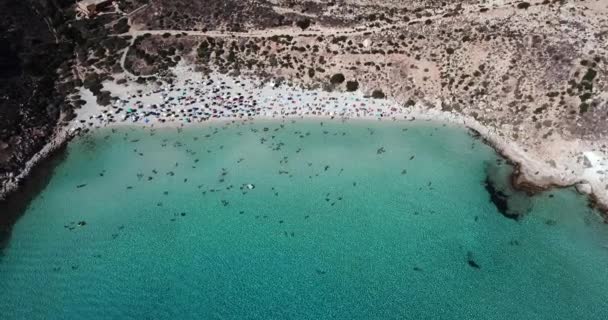 ランペドゥーサ島 シチリア島 イタリア地中海の島 Conigli の近くの島の空中写真 休日飛行ドローンを空から見ると 水泳の人とイタリアのビーチ — ストック動画