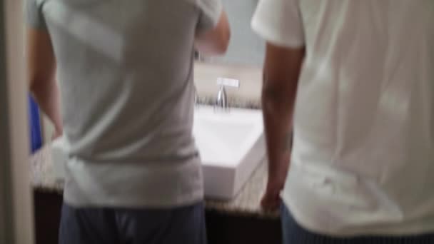 Gelukkig gay paar poetsen tanden in badkamer — Stockvideo