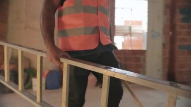 İnşaat alanında çalışan insanlar. Erkekler yeni evin içinde apartman içinde işte. Meslek ve iş için araç ve ekipman kullanarak profesyonel el ile işçilerin takım