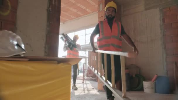 在建筑工地工作的人 公寓楼内的新房子里的男人使用工具和设备的专业人员团队 — 图库视频影像