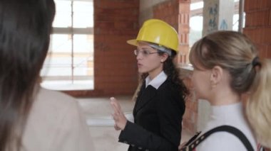 Binada müşterilerle konuşurken mimar. Şantiye mühendisi olarak müşteriler ile çalışan kadın. Proje Danışmanı gösteren ev lezbiyen çift için. Yeni ev alıcılar olarak eşcinsel kadın