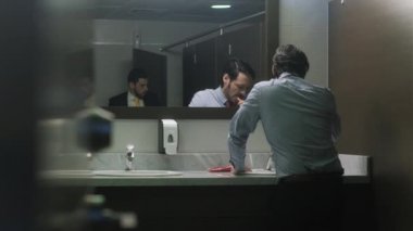 İş adamı fırçalama diş öğle yemeğinden sonra Office banyoda zorla