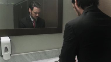 Office tuvaletler saç bakarak endişeli İspanyol iş adamı