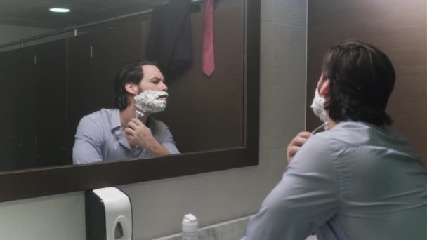 Менеджер бреется в офисных туалетах после ухода из дома для разлуки — стоковое видео