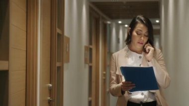 İş yerinde bir işkadını olarak Ajan ofis, mali danışman cep telefonla konuşuyor. Smartphone ile sözleşme cep telefonu müşteriye açıklayan iş kadın konuşma mutlu banka müdürü