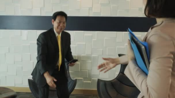 事務所でのアドバイザー 書類と金融コンサルタントとして仕事でビジネスの女性 健康保険ブローカー会議中国クライアント 退職計画エージェント待合室でアジア人と握手 — ストック動画
