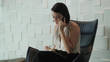 İş kadını cep telefonu ve tablet bilgisayar ile iş ofis, çalışma ve mobil telefonla konuşma meşgul Latin Sekreter. Gülümseyen, bekleme odasında İspanyol Yöneticisi olarak çalışan iş kadını