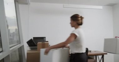 Kutuları tutarak ve adam ile yeni ofis taşıma genç latin iş kadını. Yeni iş, ona yardım meslektaşım başlatmak için beyaz işkadını çalışma Oda hazırlanıyor. İş arkadaşınız ile iş yerinde kadın Yöneticisi
