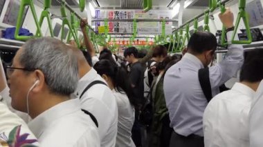 Tokyo / Japonya - Temmuz 2019: Tokyo, Japonya, Asya'da yoğun saatlerde yerel trenle gidip gelenler. Kalabalık trendeki turistler. Asyalı commuters seyahat