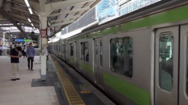Tokyo / Japonya - Temmuz 2019: Tokyo, Japonya, Asya'daki Jr Yamanote Hattı'ndaki Tokyo İstasyonu. Asyalı insanlar, turistler, Japon yolcular ve yerel tren platformda geliyor. Demiryolu, ulaşım, seyahat