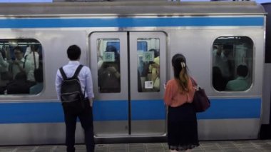 Tokyo / Japonya - Temmuz 2019: Tokyo, Japonya, Asya'da yoğun saatlerde yerel trenle gidip gelenler. Trene giren turistler. Asyalı commuters seyahat